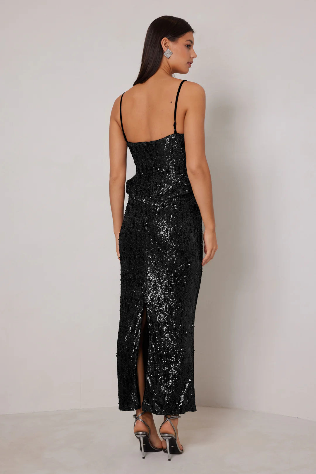 Woman wearing a black sequin dress with a white background