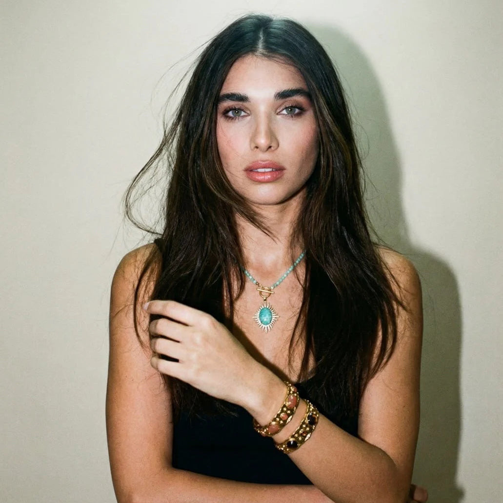 Woman wearing jewelry against a plain background