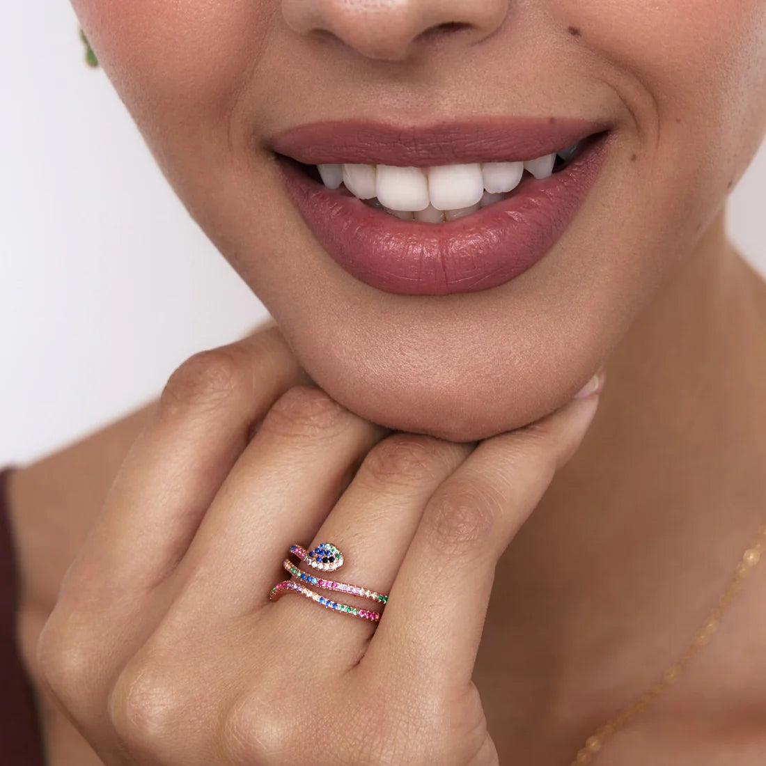 Close-up of a woman's hand with a ring, featuring a neutral background