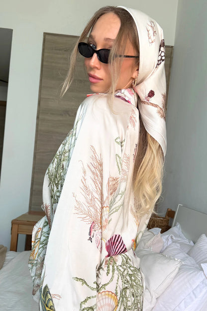 Person wearing a floral scarf and sunglasses in a bedroom setting