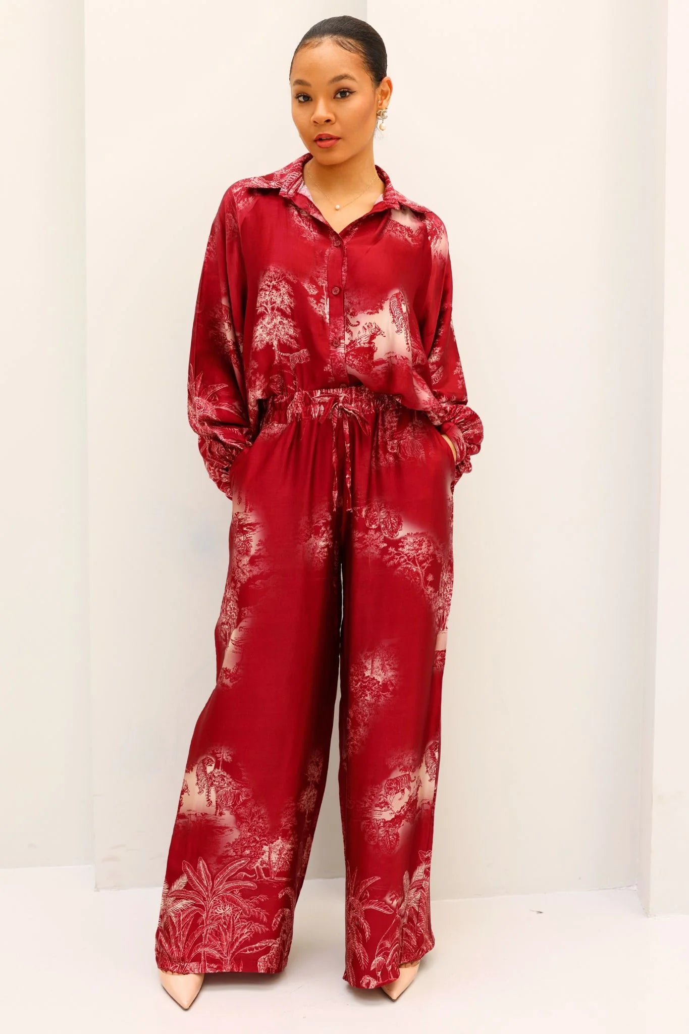 Person wearing a red tie-dye outfit on a white background