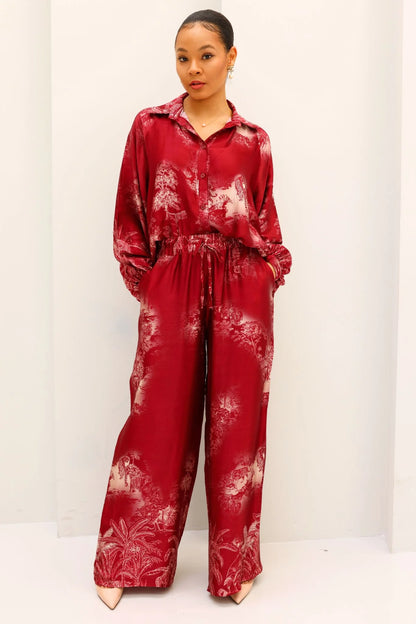 Person wearing a red tie-dye outfit on a white background