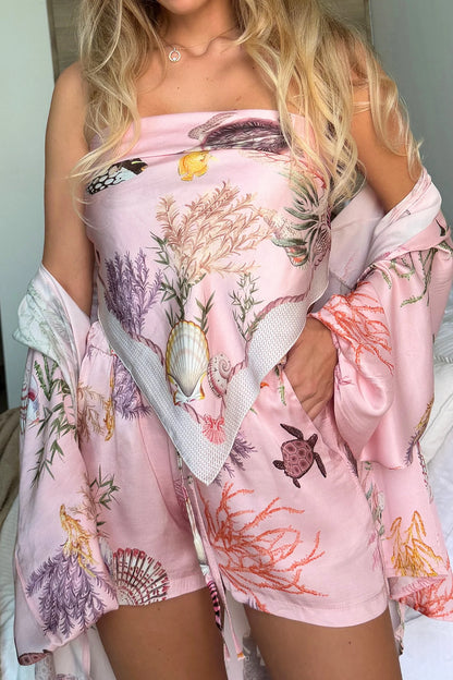 Person wearing a pink floral dress with a white kimono-style cover-up.