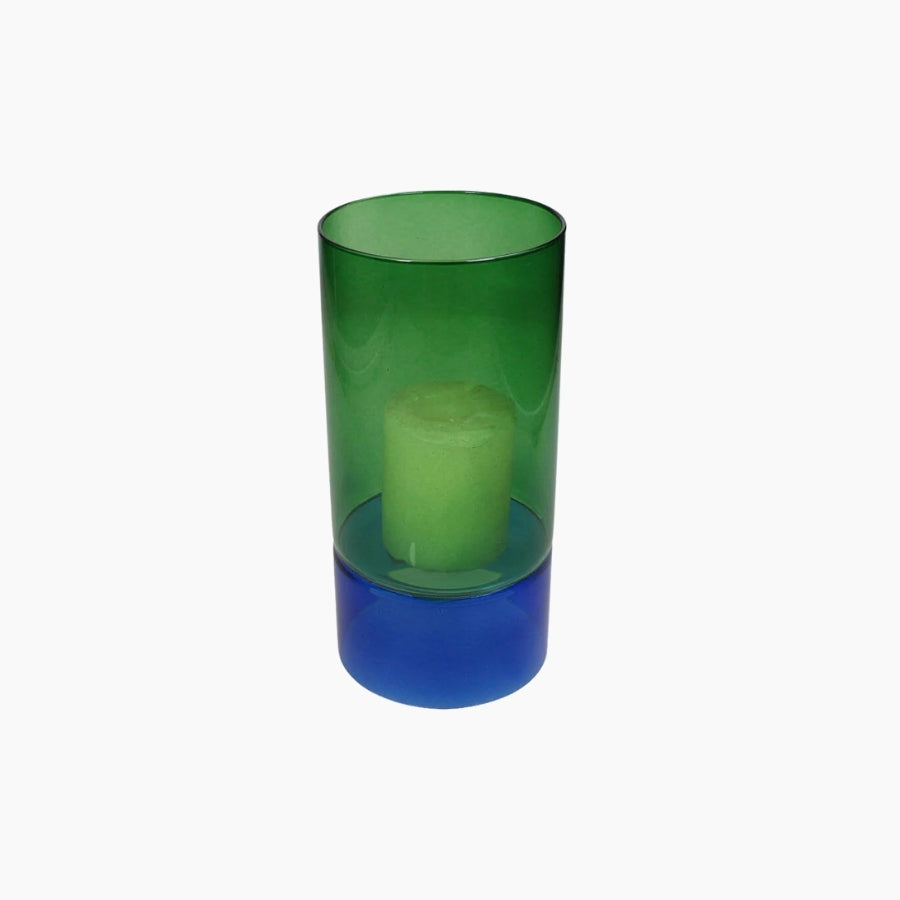 Green and blue glass candle holder with a candle inside on a white background