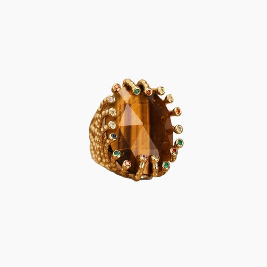 Gold ring with a large brown gemstone on a white background