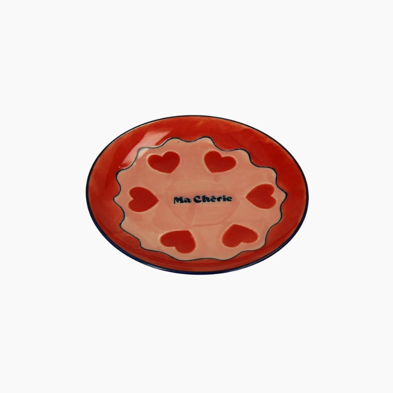 Ceramic plate with red hearts and 'Ma Chérie' text on a white background