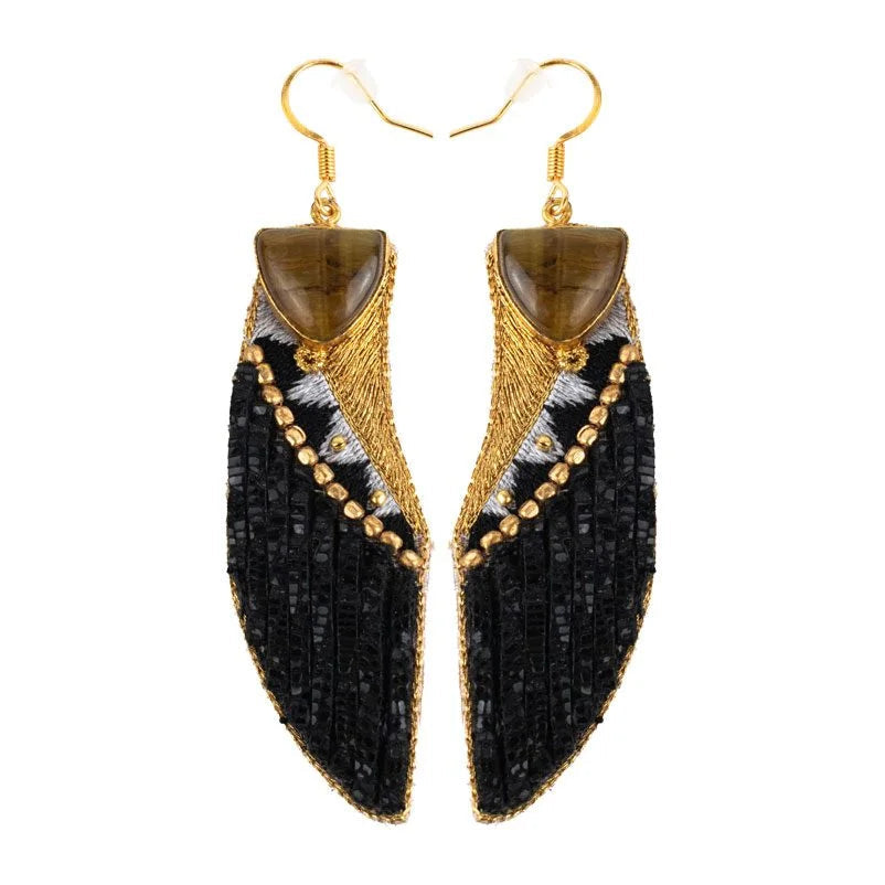 Pair of black and gold earrings on a white background