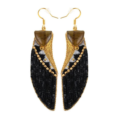 Pair of black and gold earrings on a white background