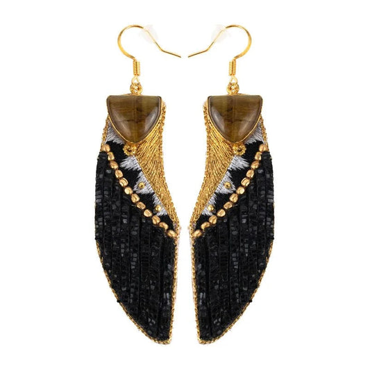 Pair of black and gold earrings on a white background