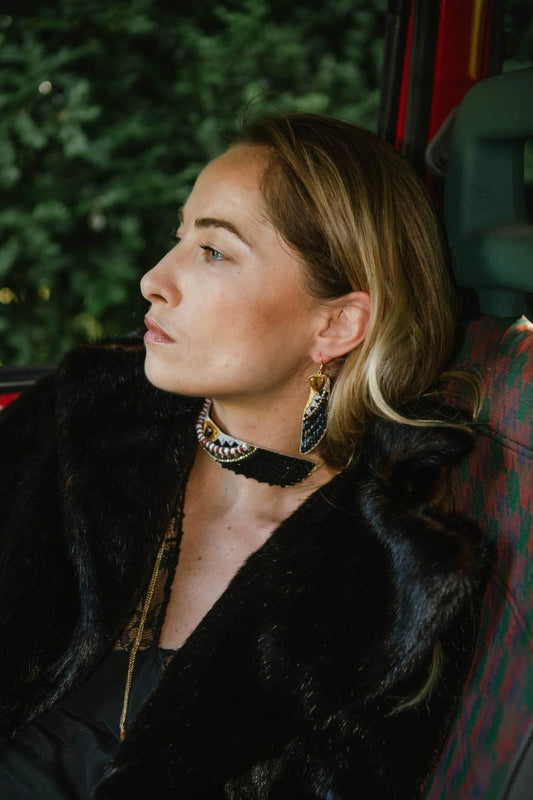 Woman wearing a black fur coat with a scenic background