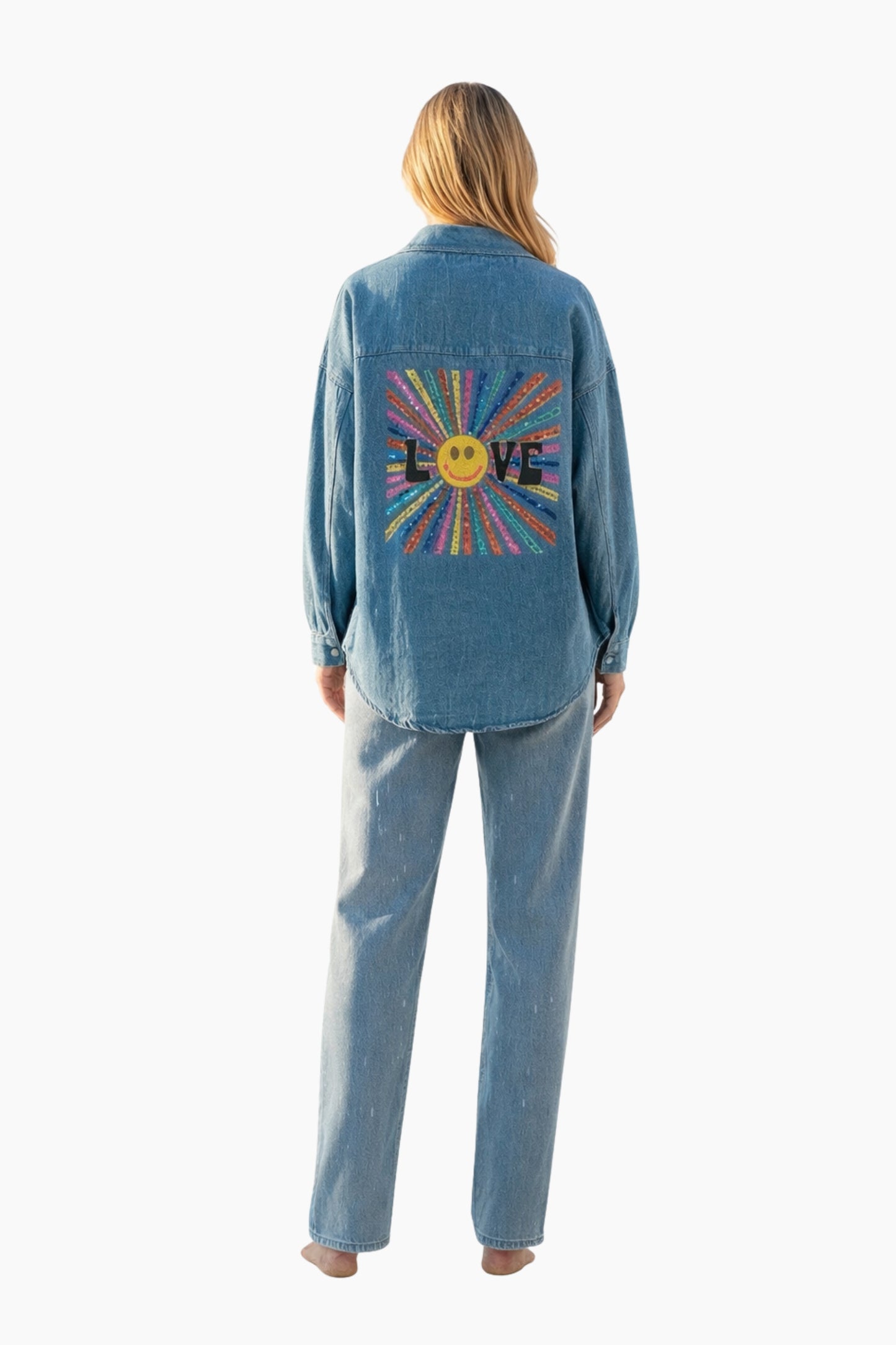 Person wearing a blue denim jacket with a colorful 'LOVE' design on the back against a white background