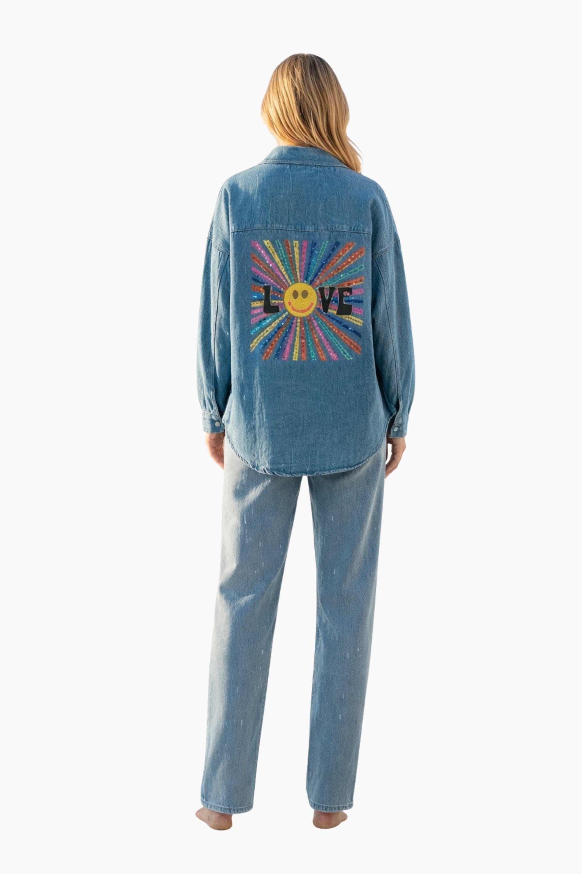 Person wearing a blue denim jacket with a colorful 'LOVE' design on the back against a white background