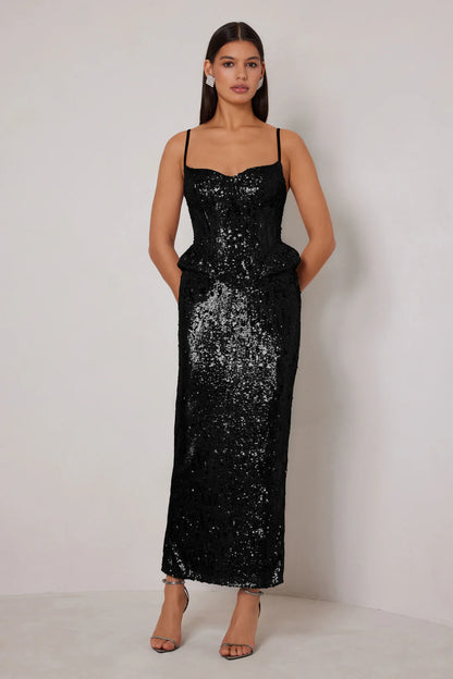 Woman wearing a black sequin dress against a white background