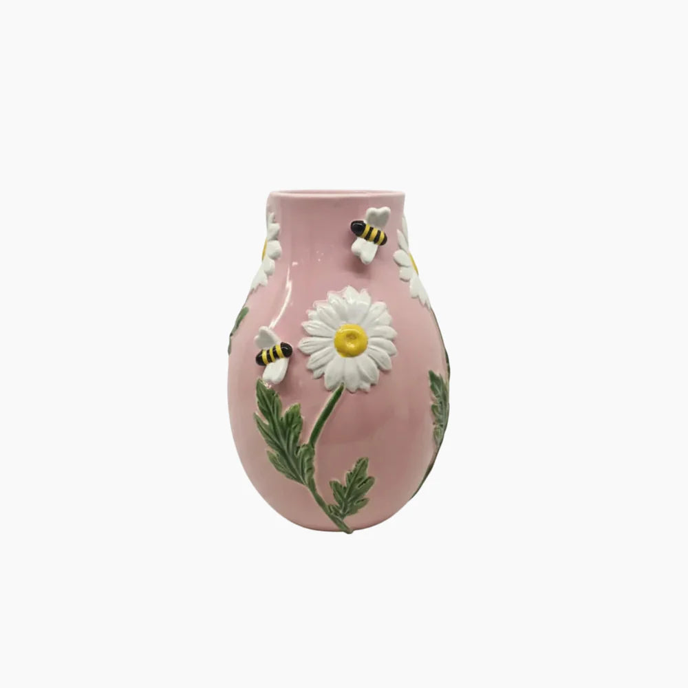Pink vase with a white daisy and bees on a white background