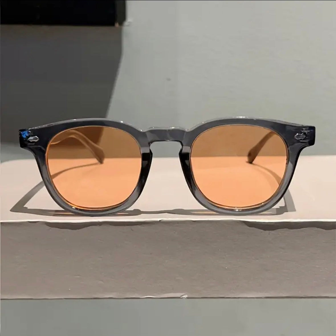 Sunglasses with brown lenses on a light gray surface