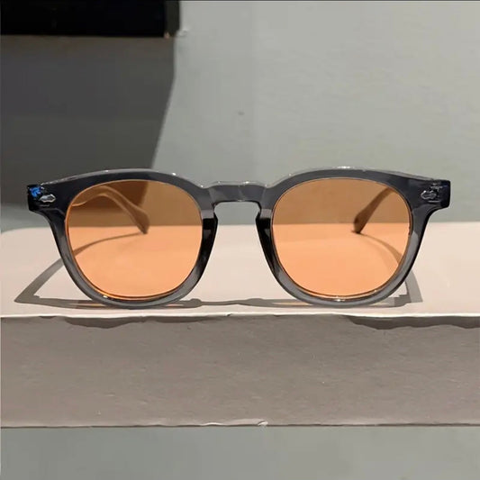 Sunglasses with brown lenses on a light gray surface