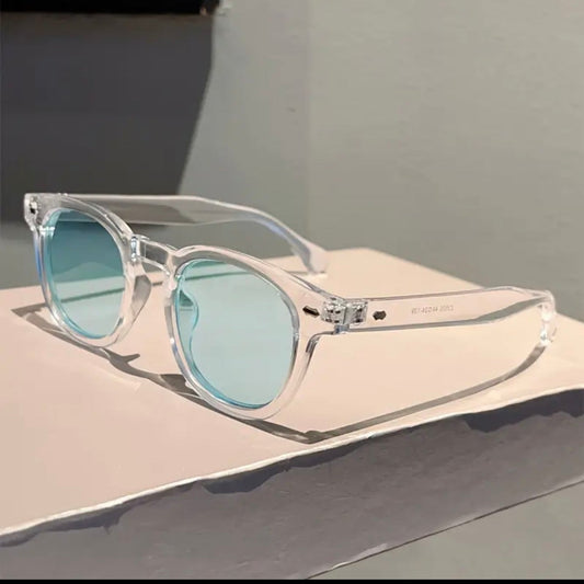 Clear sunglasses with blue lenses on a light surface
