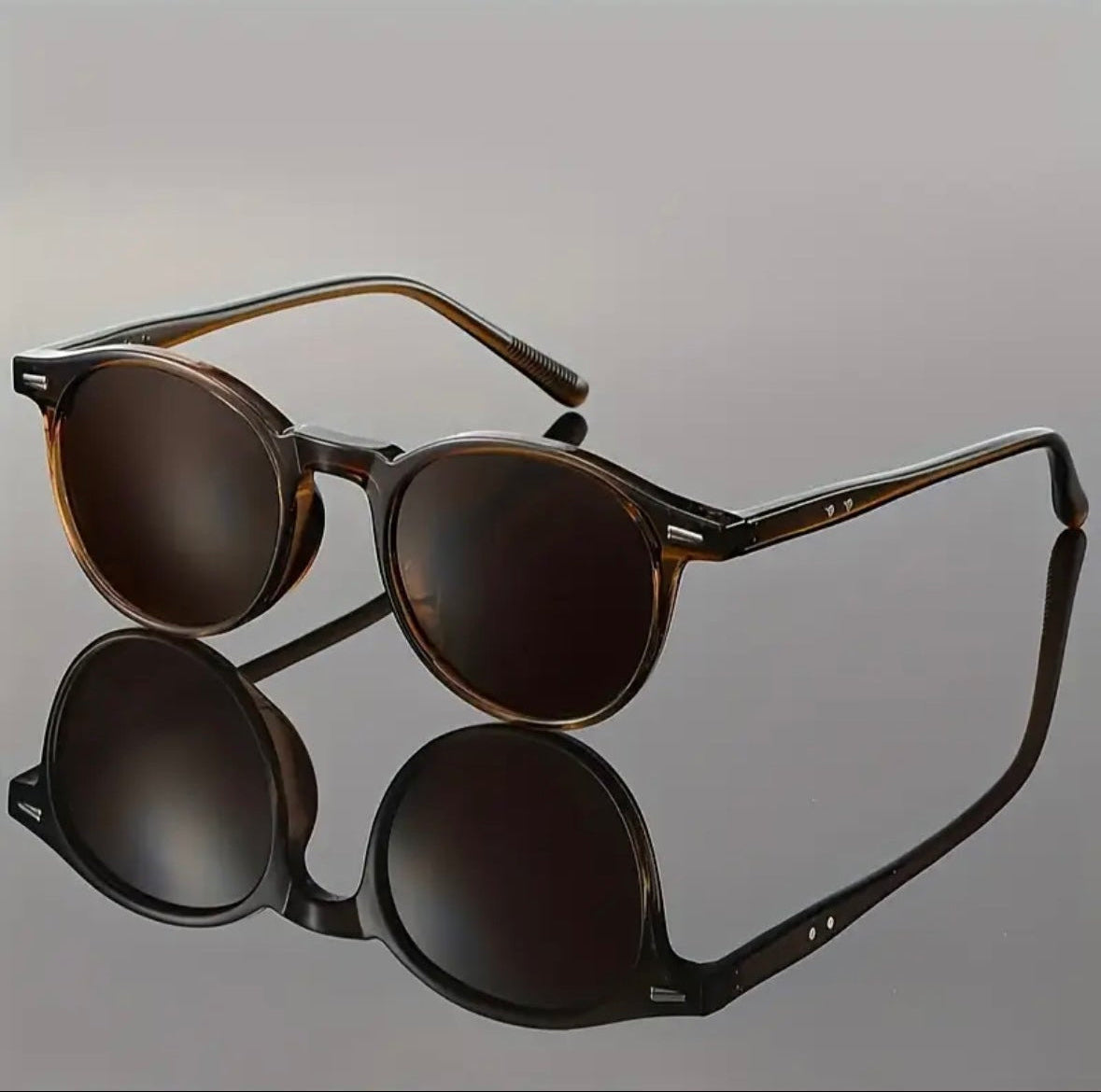 Pair of sunglasses with reflective lenses on a gray background