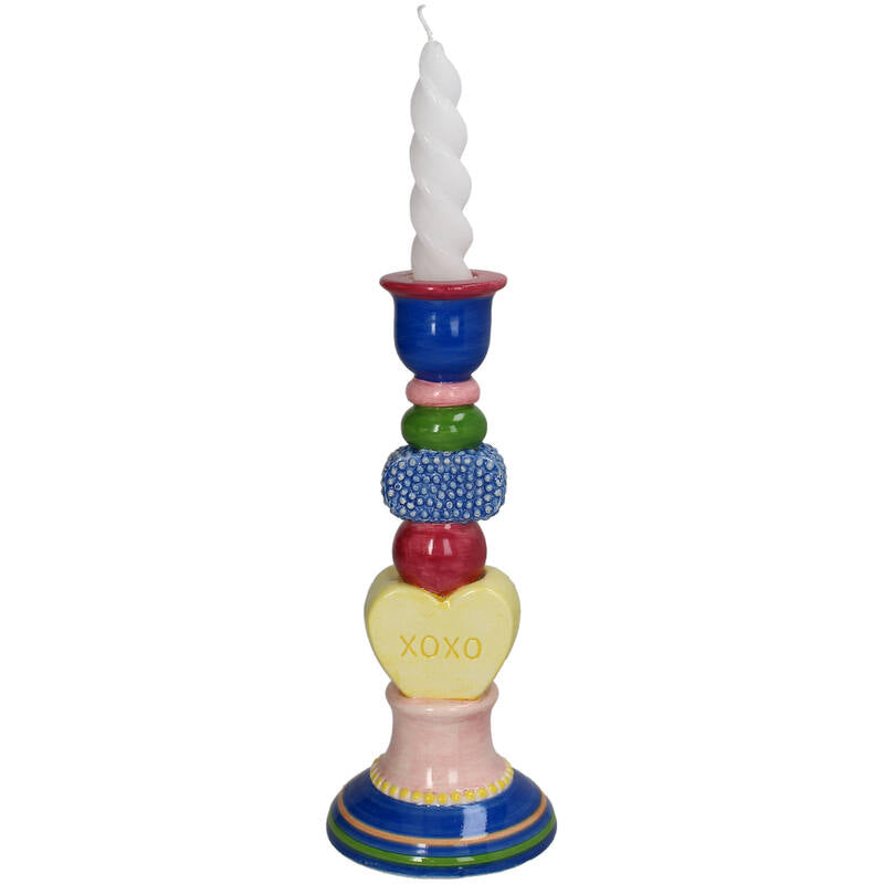 Colorful candle holder with a white candle on a white background