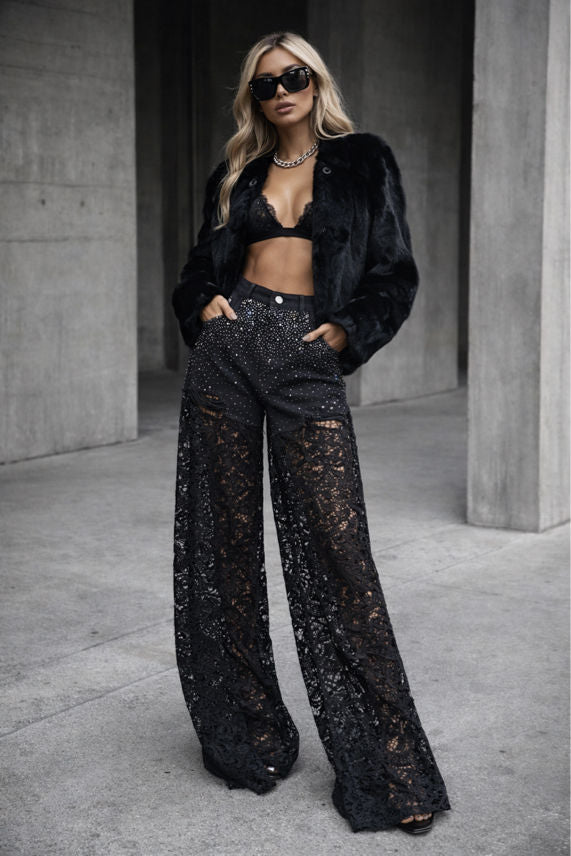 Person wearing a black outfit with lace pants in an urban setting