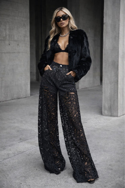 Person wearing a black outfit with lace pants in an urban setting
