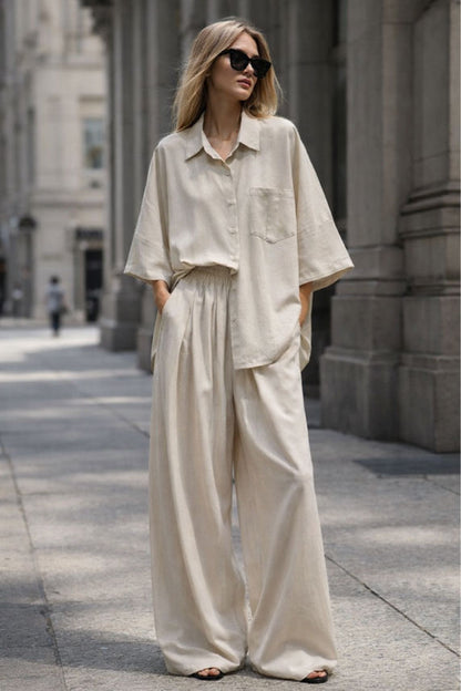 Woman wearing a beige outfit with sunglasses on a city street.