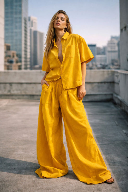 Woman in a yellow outfit standing on a rooftop with cityscape in the background