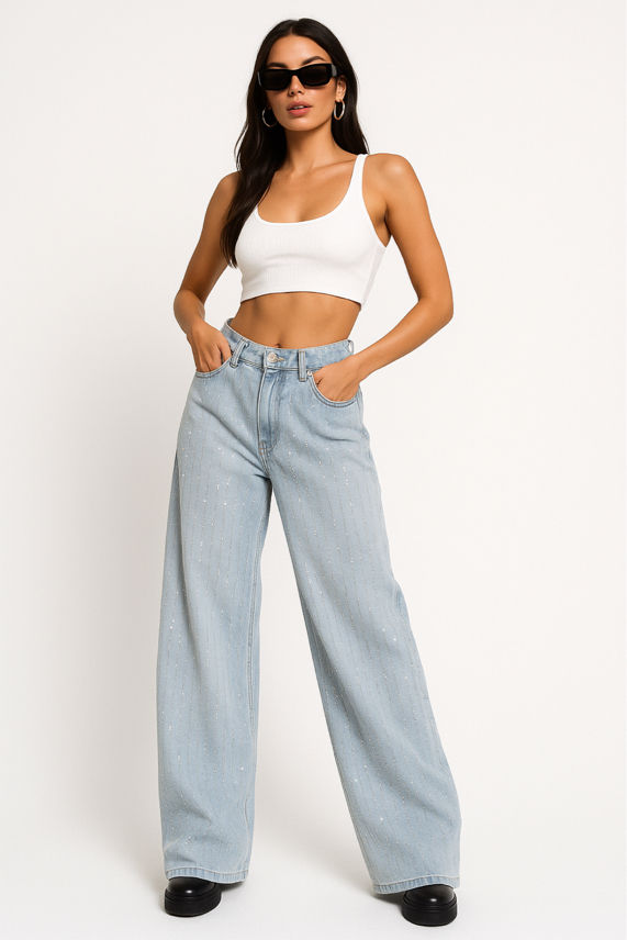 Woman wearing a white crop top and light blue jeans on a white background