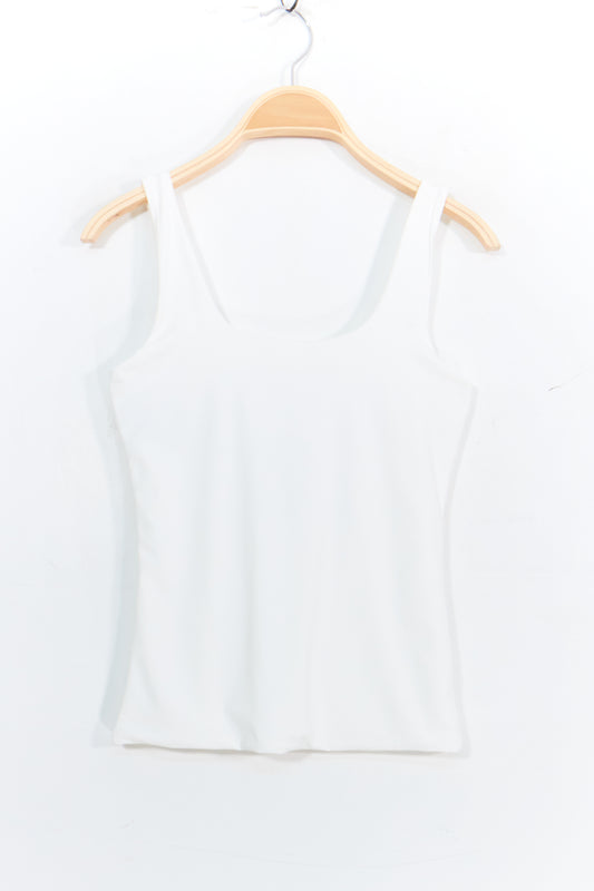White tank top on a wooden hanger against a white background