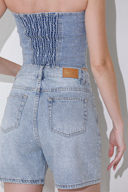 These are light-wash blue denim shorts featuring all-over rhinestone embellishments and a high-rise waist.