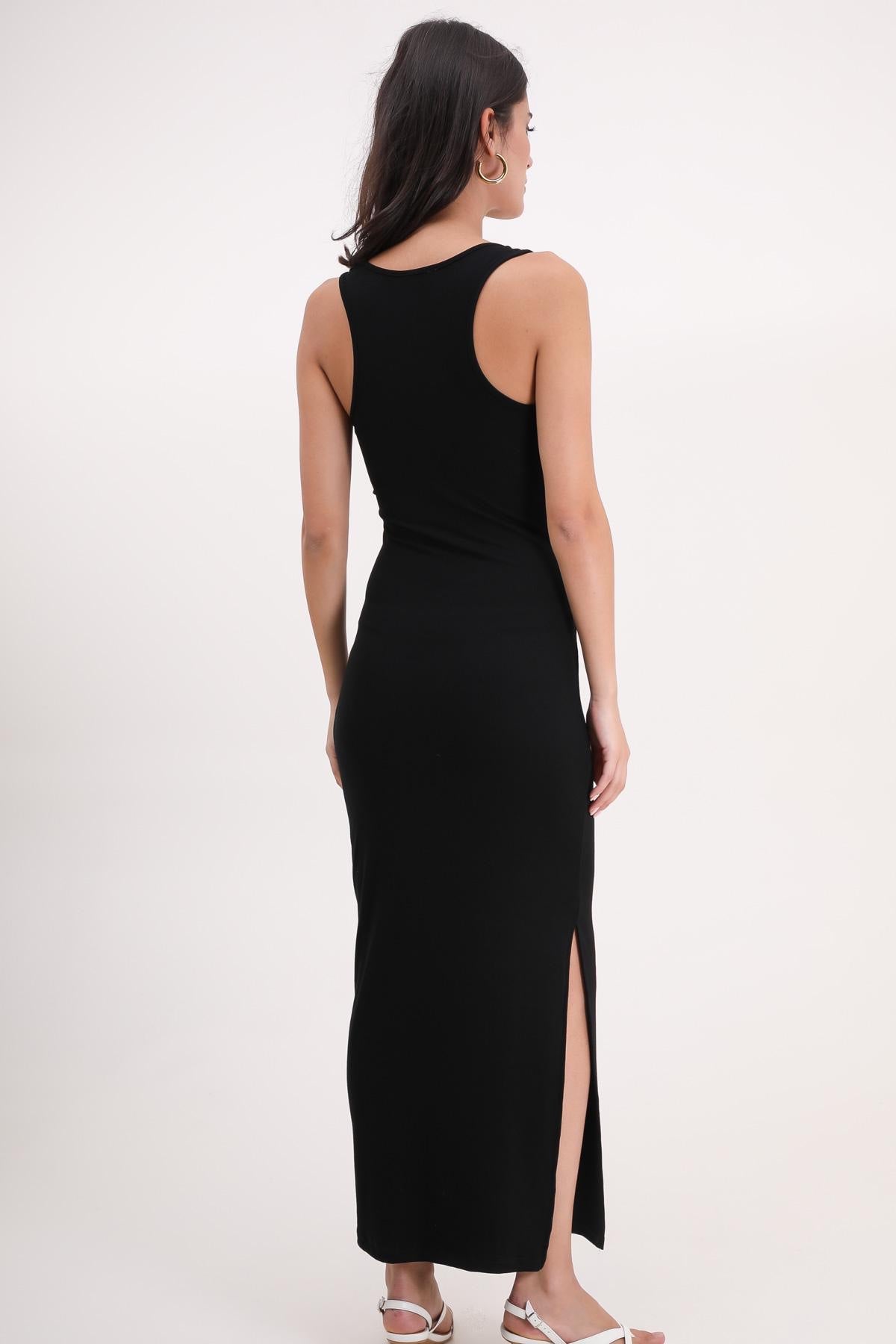 Woman wearing a black sleeveless dress with a slit on a white background