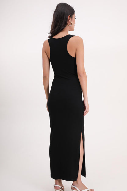 Woman wearing a black sleeveless dress with a slit on a white background