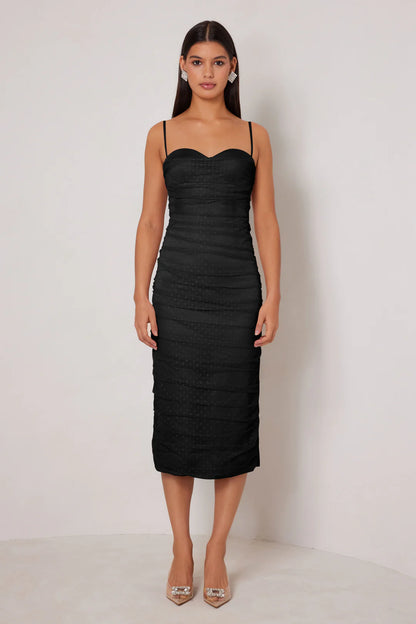 Woman wearing a black strapless dress against a white background