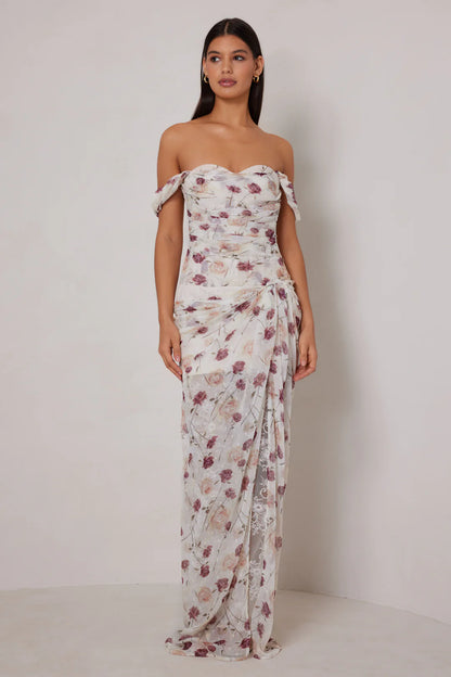Woman wearing a floral strapless gown against a plain background