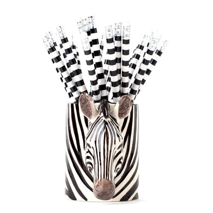 Zebra-themed vase with black and white striped paper straws on a white background