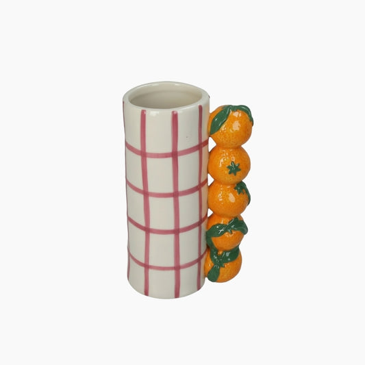 Ceramic mug with plaid design and decorative oranges on a white background