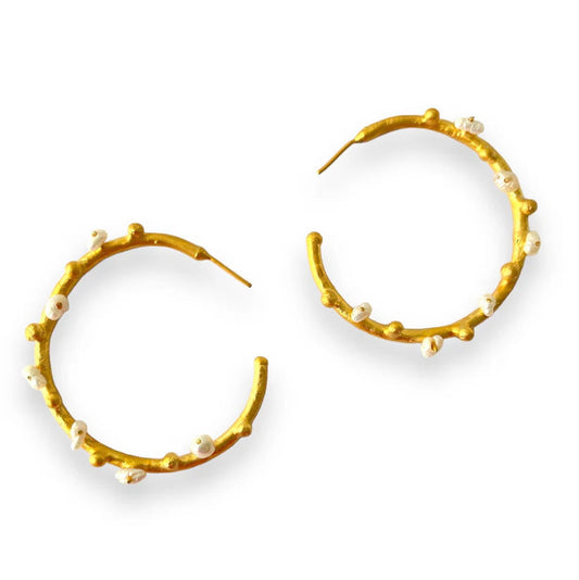 Gold hoop earrings with pearl-like beads on a white background