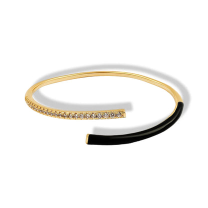Gold and black bracelet with diamond accents on a white background