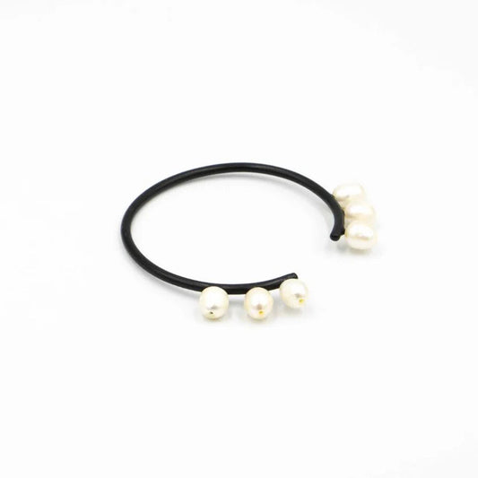 Black hair tie with three pearls on a white background