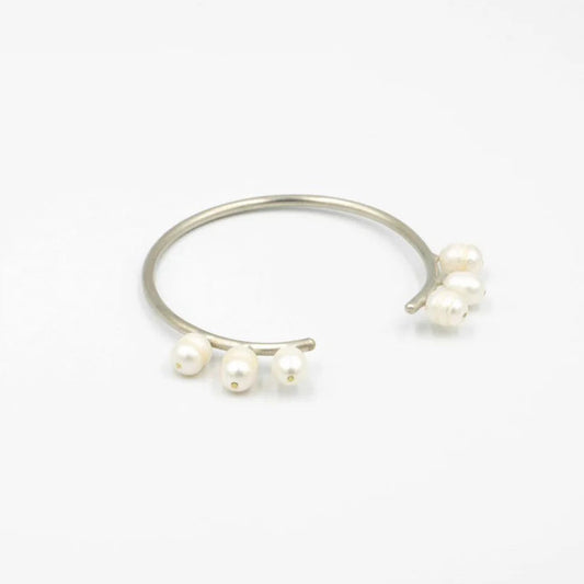 Silver ring with three pearls on a white background