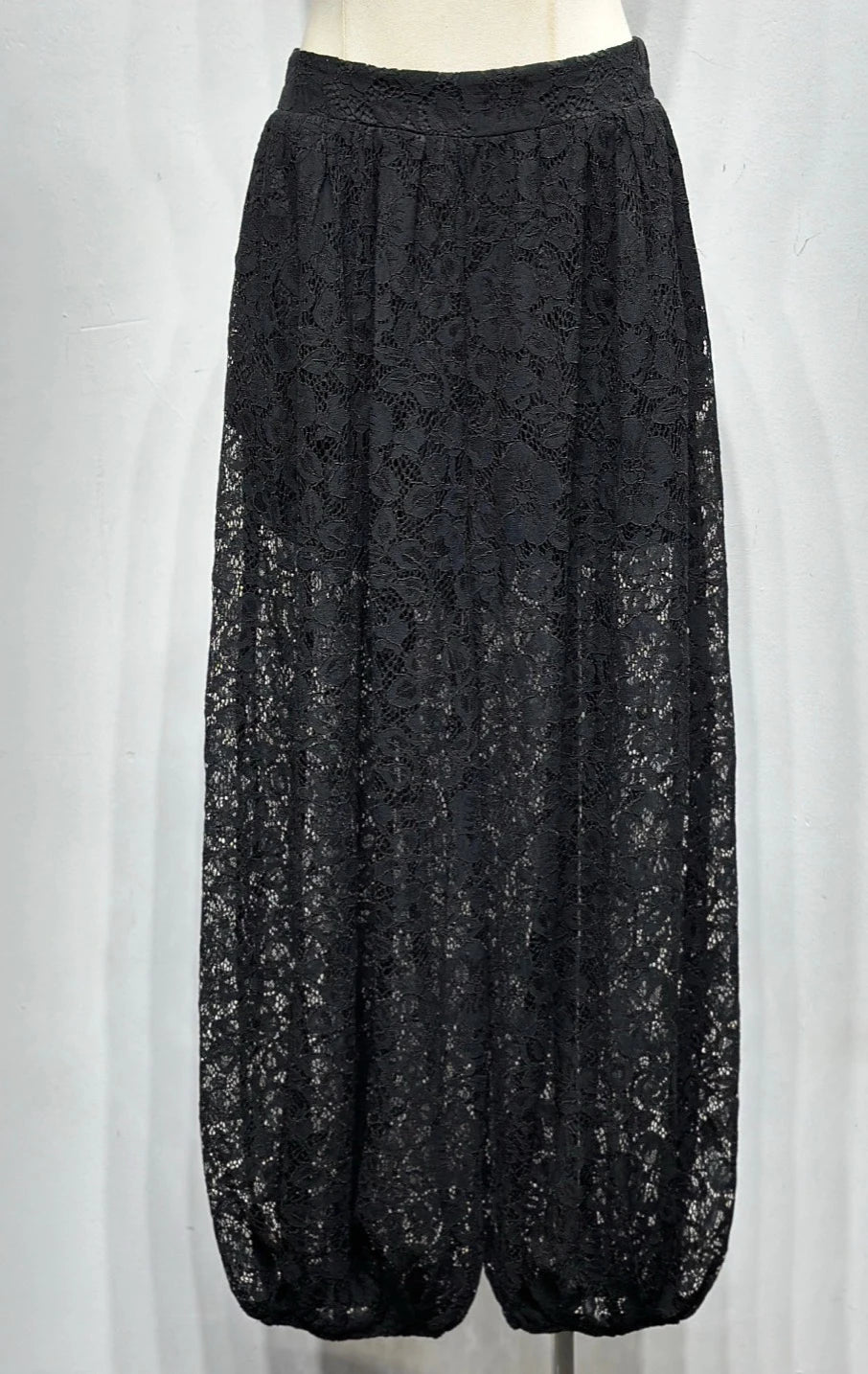Black lace pants on a white mannequin against a white background