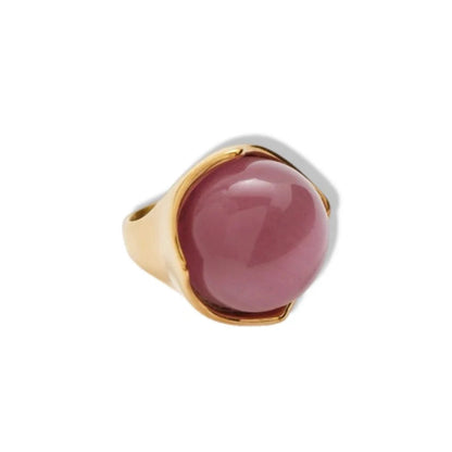 Ring with pink stone and gold band on a white background