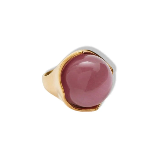 Ring with pink stone and gold band on a white background