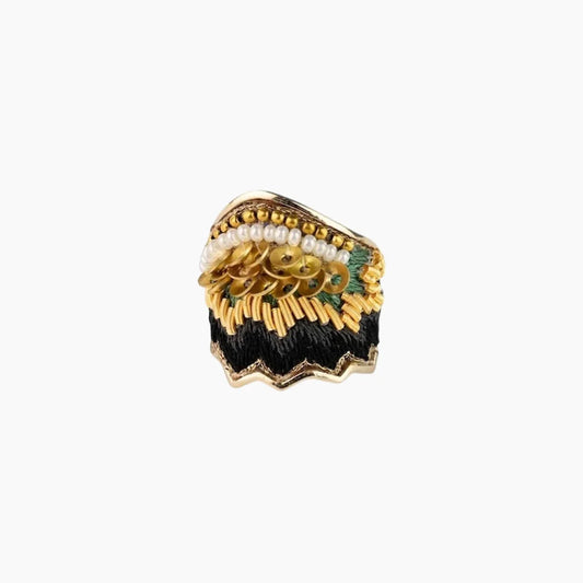 Decorative brooch with gold, pearl, and green elements on a white background