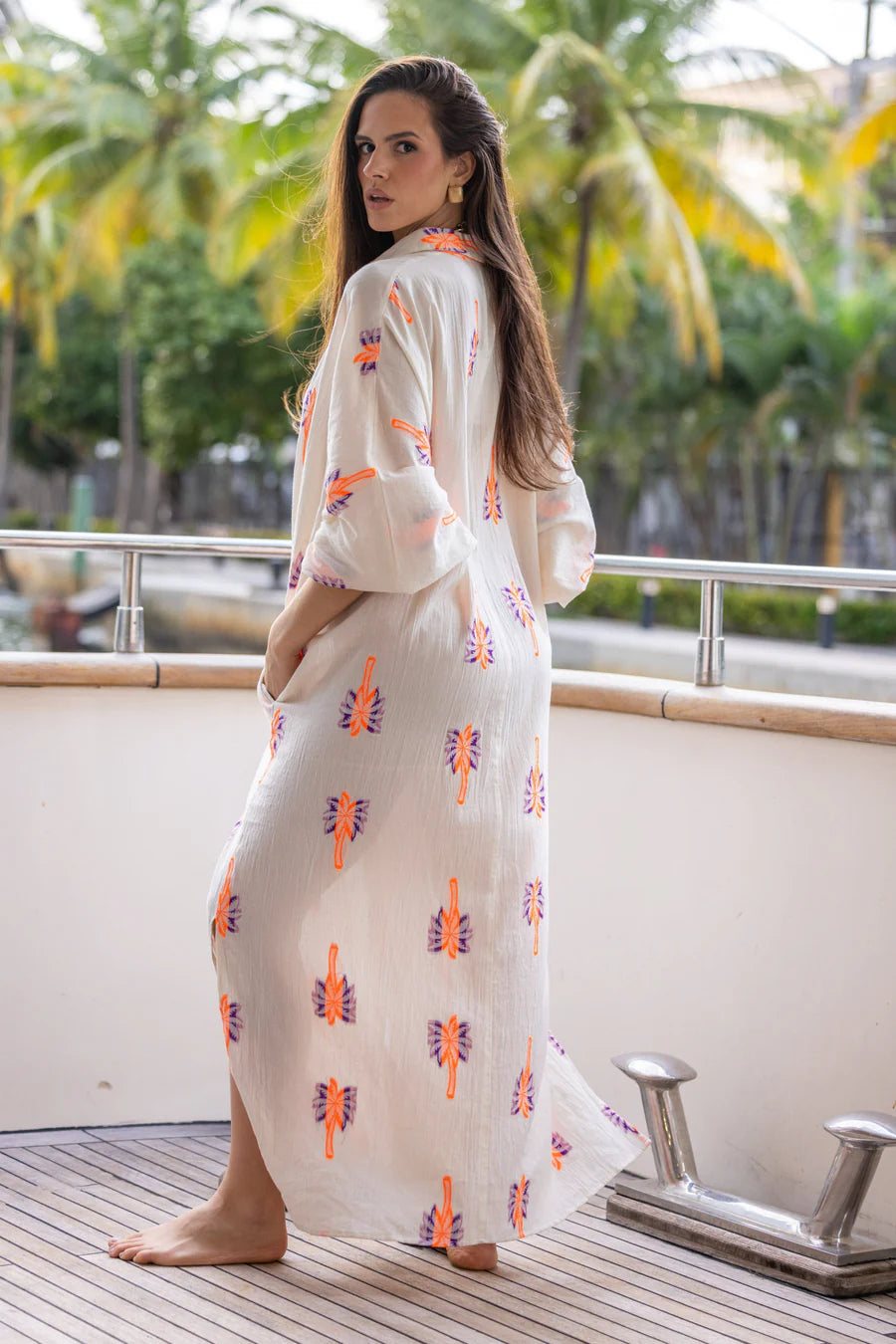 Long bohemian-style shirt dress made from a light and flowy fabric. Its full-length button closure and loose fit create a relaxed yet elegant silhouette.
Decorated with colorful embroidered patterns, it can be worn closed as a dress or open as a layering piece for different styling options