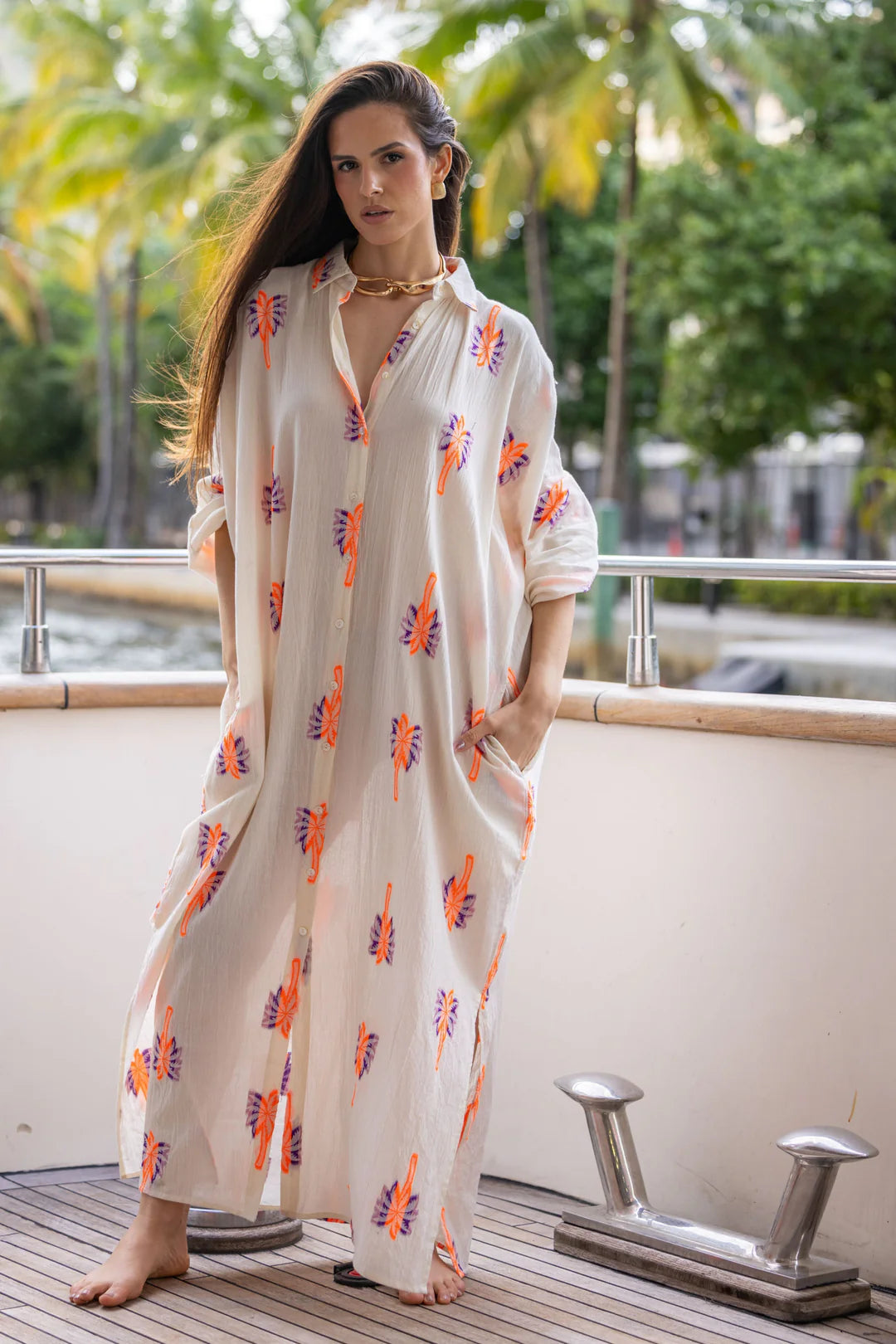 Long bohemian-style shirt dress made from a light and flowy fabric. Its full-length button closure and loose fit create a relaxed yet elegant silhouette.
Decorated with colorful embroidered patterns, it can be worn closed as a dress or open as a layering piece for different styling options