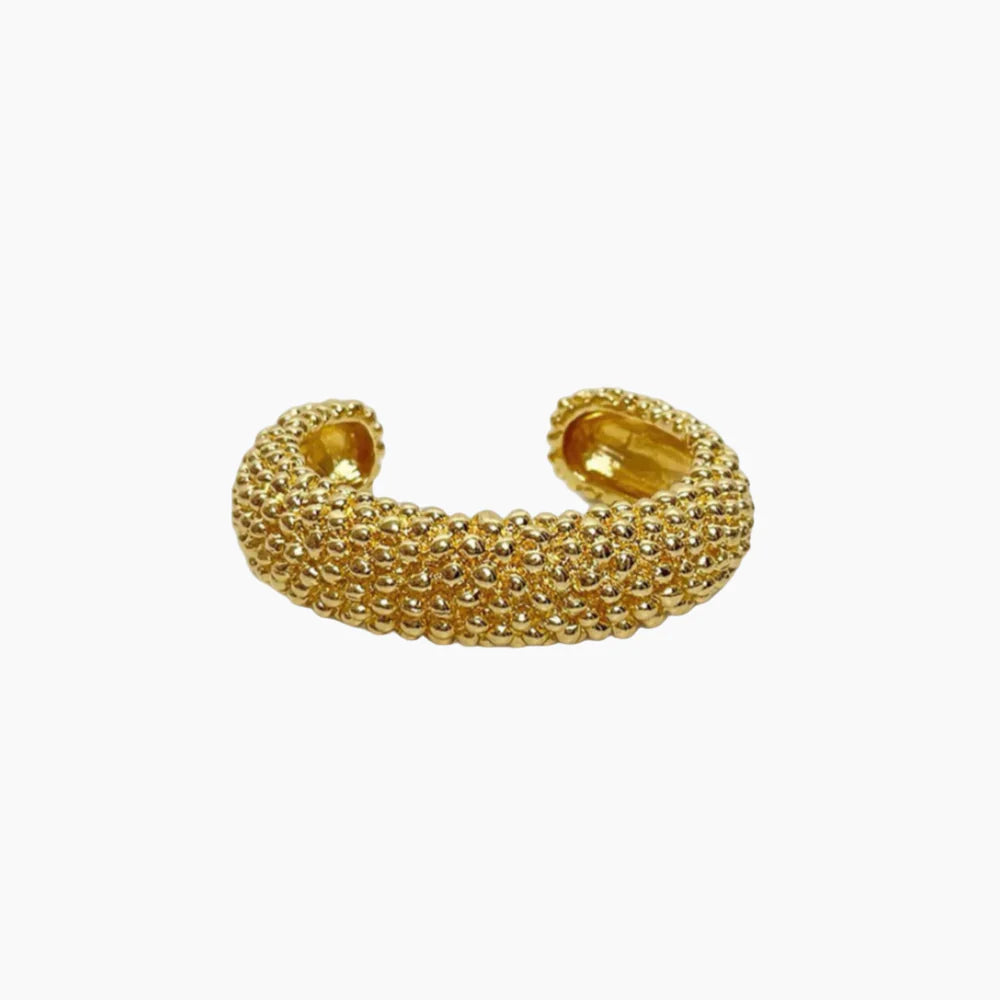 Gold beaded cuff bracelet on a white background