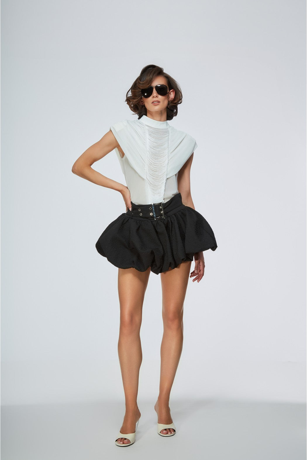 Woman wearing a white top and black skirt on a white background