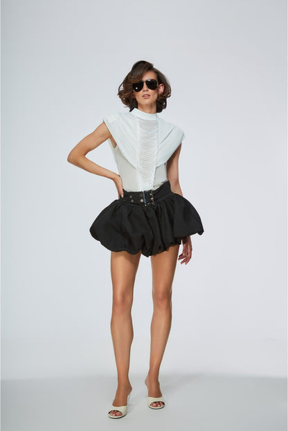 Woman wearing a white top and black skirt on a white background