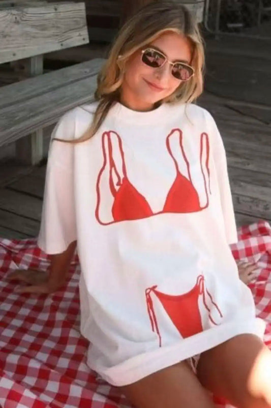 Person wearing a white sweatshirt with red bikini graphic on a wooden deck.